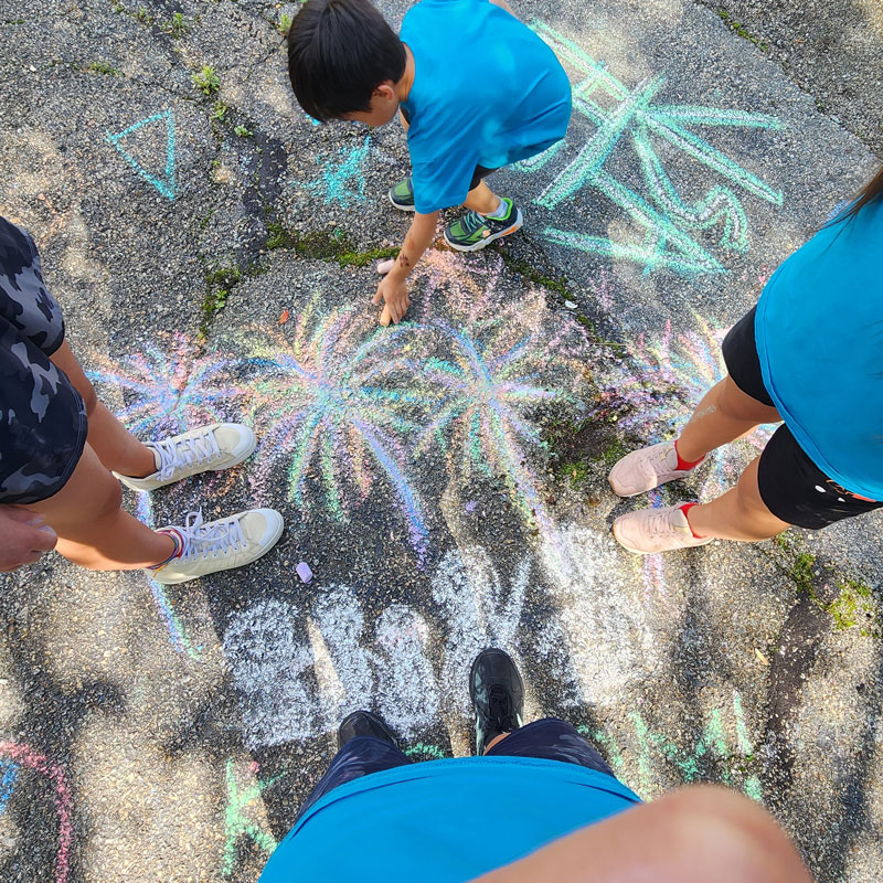 kids drawing with sidewalk chalk